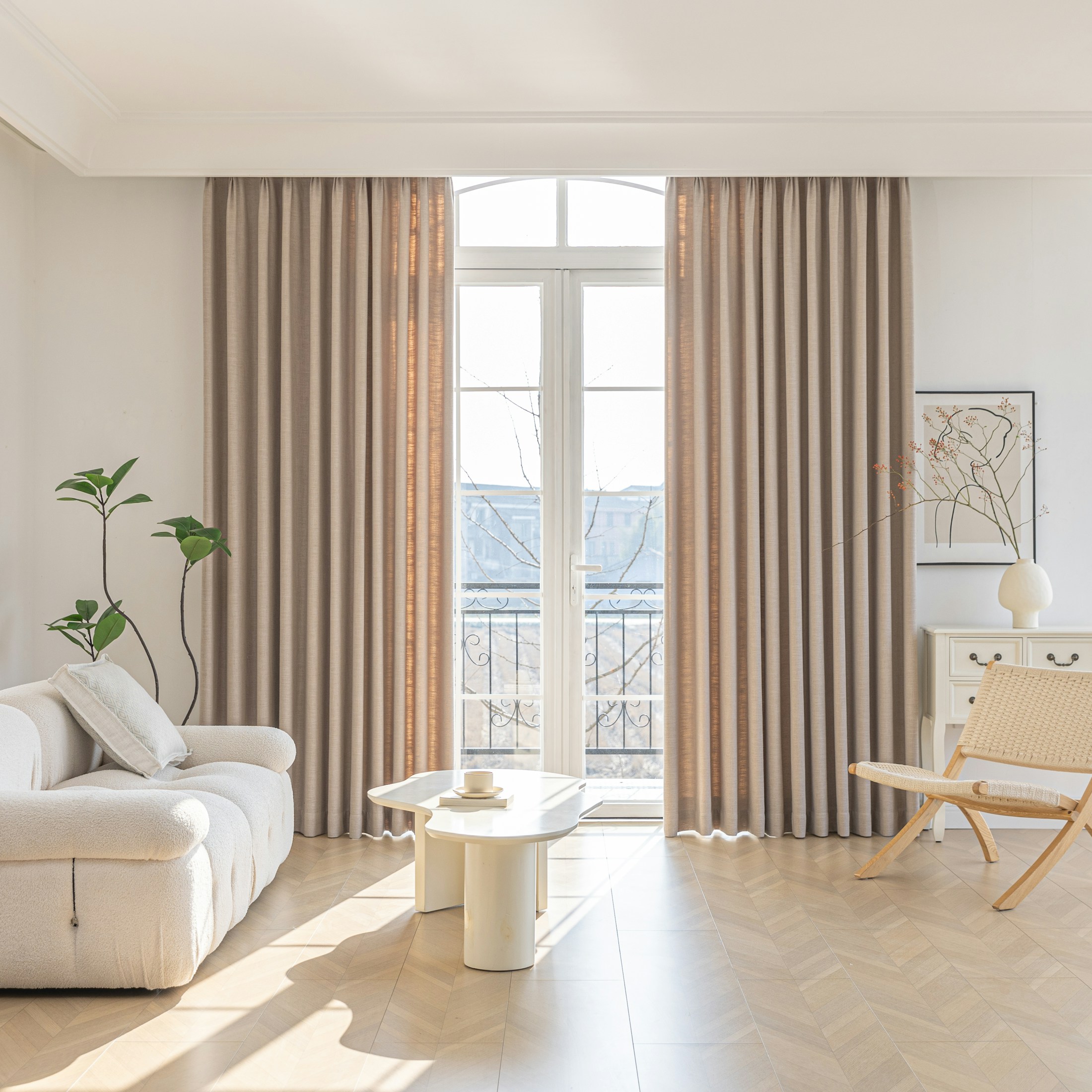 Sunlit living room with a curved ivory sofa, warm wood and textured neutral finishes